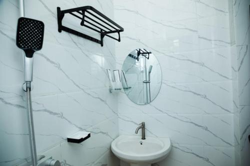 a white bathroom with a sink and a mirror at Angel homestay hotel in Mikumi