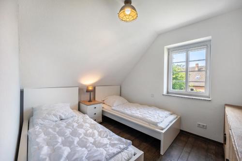 a bedroom with two beds and a window at Haus Am Dorfteich B eingefriedet in Fehmarn