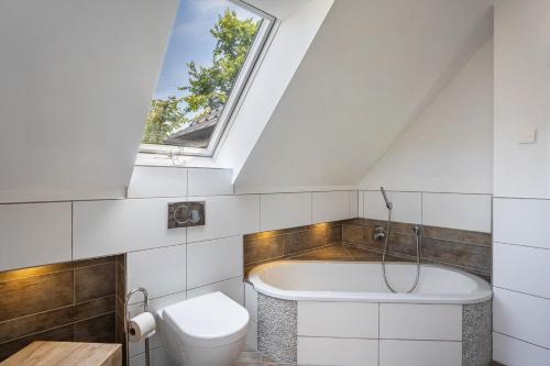 a bathroom with a toilet and a bath tub at Haus Am Dorfteich B eingefriedet in Fehmarn