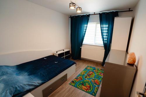 a bedroom with a bed and a window and a rug at Danube Breeze Apartment in Giurgiu