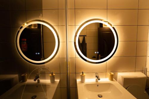two mirrors above a sink in a bathroom at Danube Breeze Apartment in Giurgiu