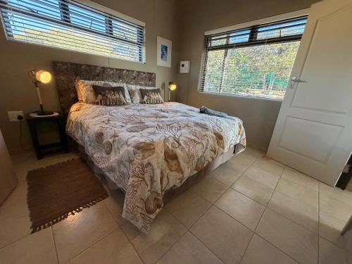 a bedroom with a large bed and a large window at Karibu Self-Catering unit 2 in Omaruru