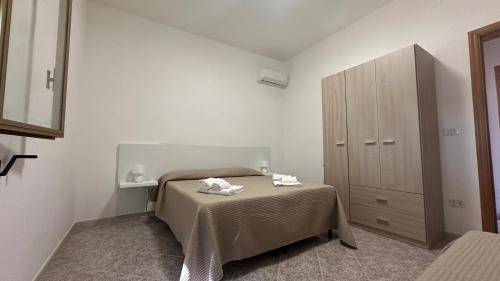 a bedroom with a bed with two towels on it at Li Geusi in Torre Lapillo
