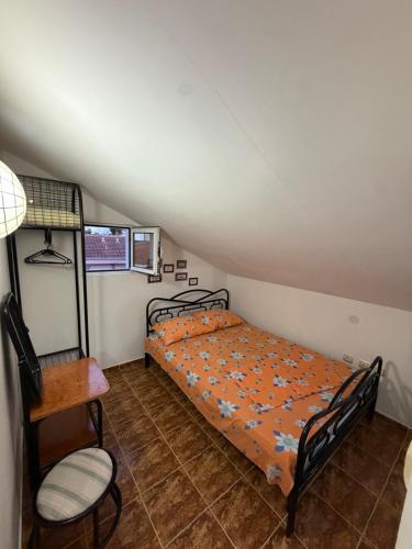 a bedroom with a bed and a chair in a attic at ADM Apartment in Bečići