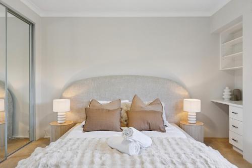 a bedroom with a large white bed with two lamps at The Aveley Retreat in The Vines