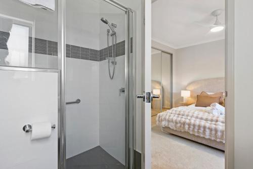 a bathroom with a shower and a bed in a room at The Aveley Retreat in The Vines