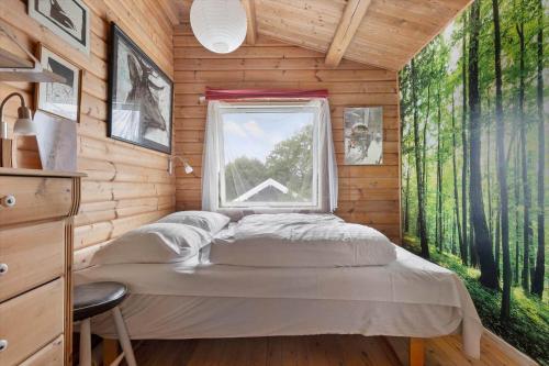 a bedroom with a bed and a window in a log cabin at 1693-Kikhavn-Kragevejen-3 in Kikhavn