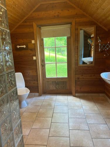 a bathroom with a toilet and a window at Lommen in Dals Långed