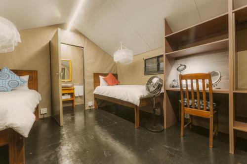 a room with two beds and a desk and a chair at The Explorers Camp in Renos