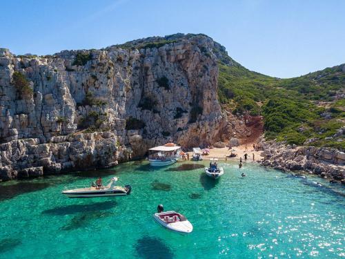 a group of boats in the water at a beach at Ionian Waves Villa - Marathopoli Stylish Escape in Marathopoli