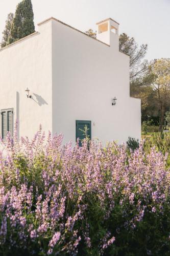 a white building with purple flowers in front of it at Tenuta Doxi in Gallipoli