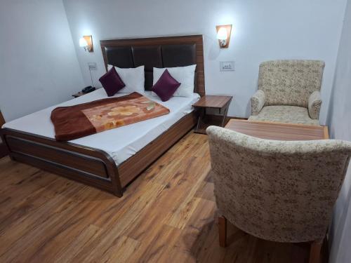 pokój hotelowy z łóżkiem i krzesłem w obiekcie Hotel Moon In w mieście Kullu