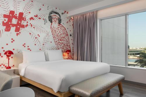 a bedroom with a bed with a bird on the wall at Radisson RED Dubai Silicon Oasis in Dubai