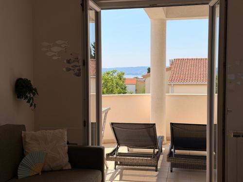 a living room with a couch and chairs on a balcony at TIMO Apartment Split Croatia in Kaštela