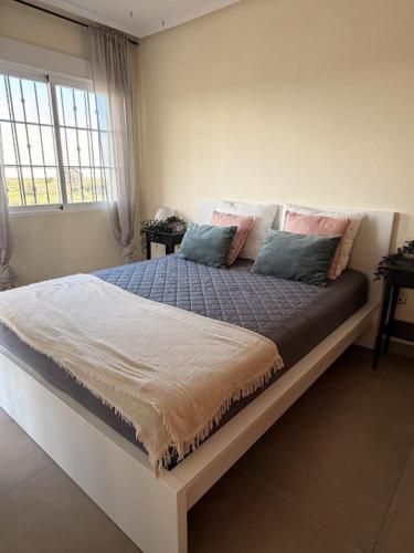 a bedroom with a large bed with pink and blue pillows at Salona Geus in Algorfa