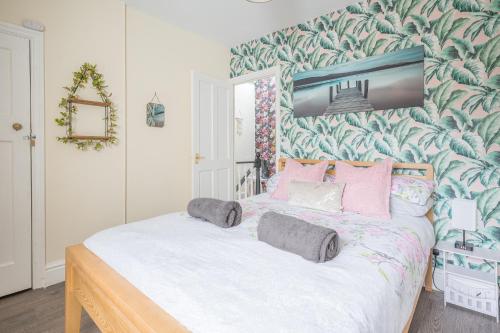 a bedroom with a large bed with pink pillows at Charming Cottage, Lake District in Little Broughton