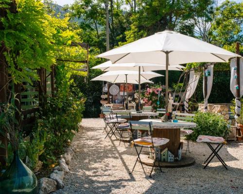 an outdoor patio with tables and umbrellas at B&B LE GRETTE in Gioia dei Marsi