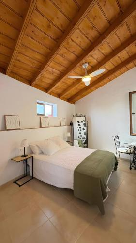 a bedroom with a large bed and a wooden ceiling at Lagar de Elba in Las Manchas