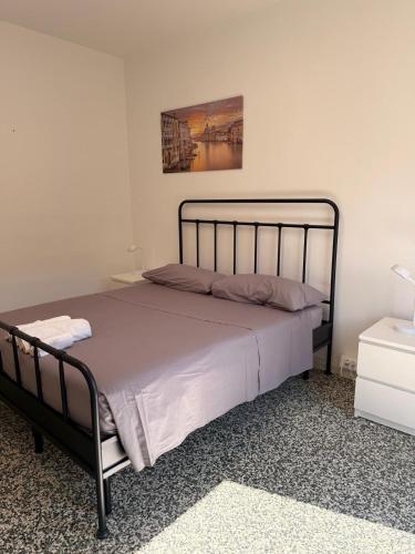 a bed in a white room with a black frame at Villa Cecilia in Portogruaro