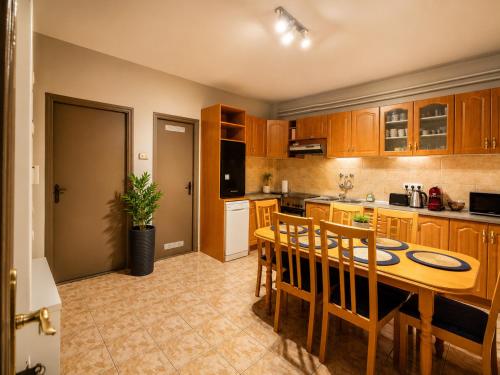 a kitchen with a wooden table and wooden cabinets at Sefira Homes Y in Keszthely