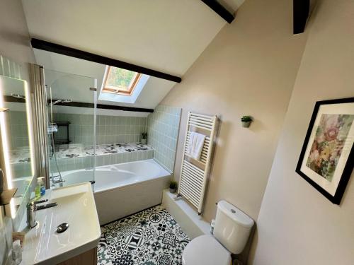 a bathroom with a tub and a toilet and a sink at Quai du Val is a Charming Pet and Family Friendly Riverside Gite in Lehon close to Dinan Sleeps 7 in Dinan