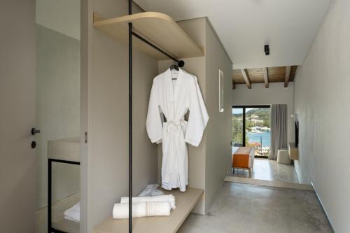 a dressing room with a white robe hanging on a wall at KHAI Syvota in Syvota