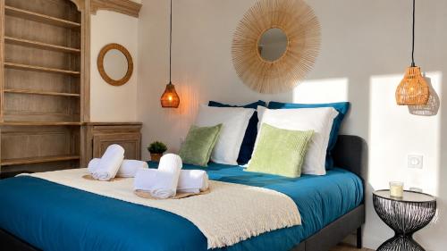 a bedroom with a blue bed with towels on it at Le Jardin de Villevaudé, proche Disney & Paris in Villevaudé