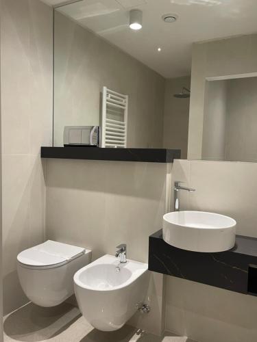a bathroom with a sink and a toilet and a mirror at Hotel Serafino in Padova