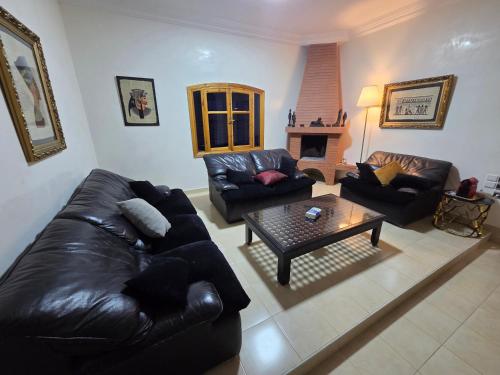 a living room with a leather couch and a coffee table at la Citronnelle in Oualidia