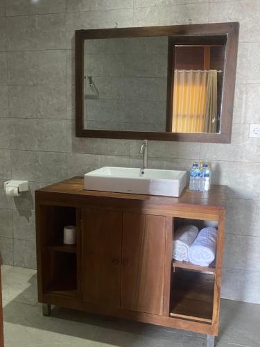 a bathroom vanity with a sink and a mirror at Linda Beach Hotel in Nusa Lembongan