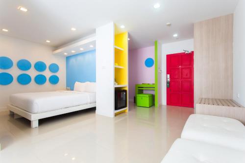 a bedroom with two beds and a red door at Samui Verticolor in Chaweng
