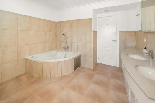 a large bathroom with a tub and two sinks at Sun & Golf Stay in Baños y Mendigo