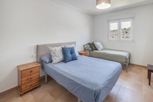 a bedroom with a bed and a chair in it at Sun & Golf Stay in Baños y Mendigo