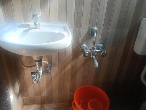 a white sink in a bathroom with wooden walls at ZOLO Stays in Chennai