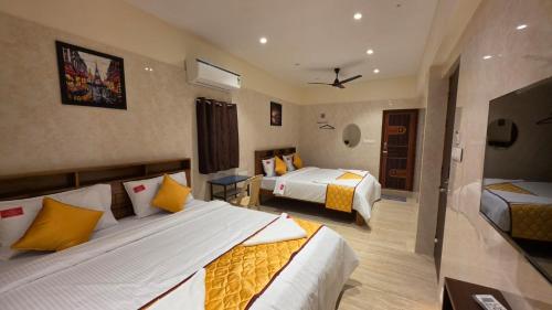 a hotel room with two beds in a room at Kanchi Crown Residency in Kanchipuram