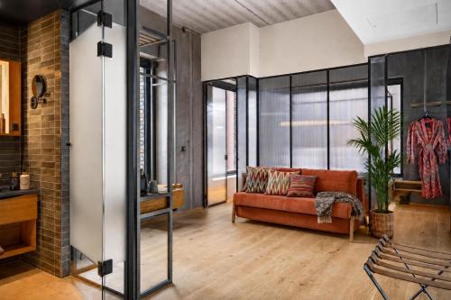 a living room with a red couch and glass walls at Belle Guldsmeden in Aarhus
