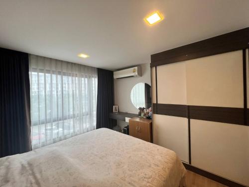 a bedroom with a large bed and a window at Living avenue condominuim in Ban Rong Khoei