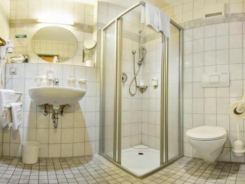 a bathroom with a shower and a sink and a toilet at Hotel Gasthof zum Ochsen in Ehingen
