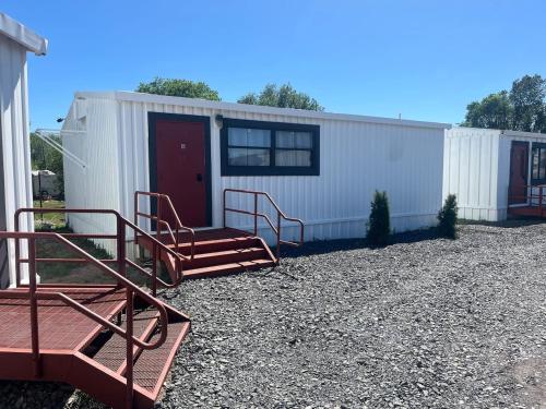 a small white trailer with a red door and two chairs at Athens House nuber 8 in Las Vegas