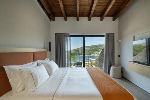 a bedroom with a large bed with a large window at KHAI Syvota in Syvota