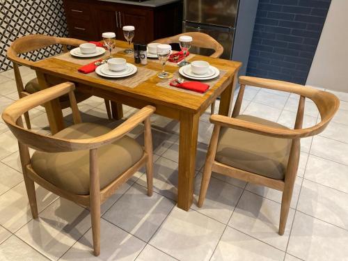 a wooden table and chairs with wine glasses on it at Ntaba Villas in Port St. Johns