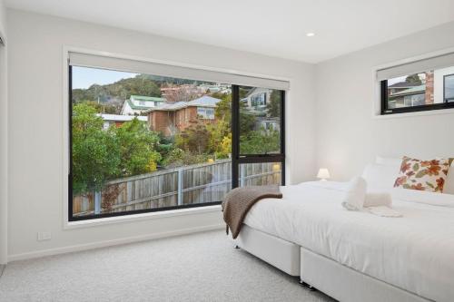 a bedroom with a bed and a large window at Modern Lindisfarne Escape in Lindisfarne