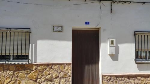 a white building with a door and two windows at Casa tío Manolo in Sinarcas
