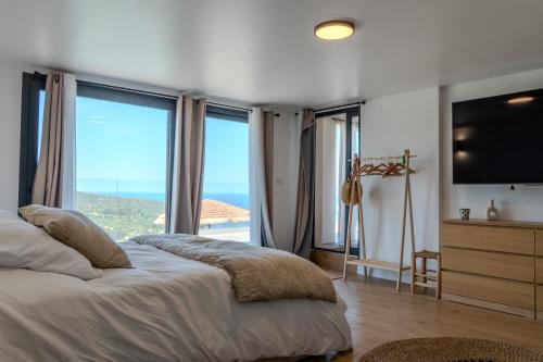a bedroom with a bed and a large window at Villa ROYA in Saint-Florent