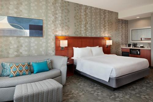 a hotel room with a bed and a couch at Courtyard by Marriott Ottawa East in Ottawa