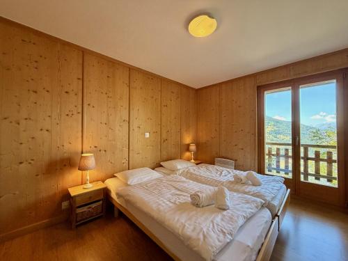 a bedroom with a large bed and a large window at Tschoueilles 009 MOUNTAIN & VIEW - chalet 12 pers in Veysonnaz