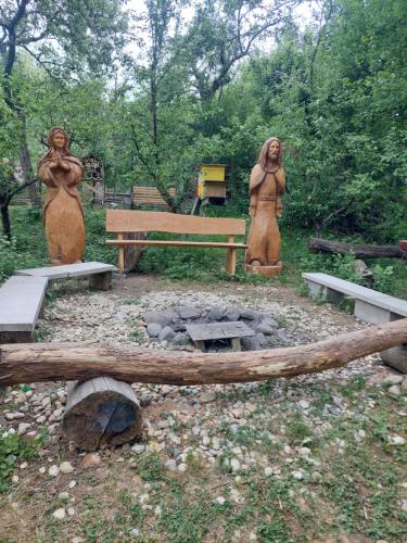 two statues of women standing next to a fire pit at Api terapia Bojnice in Bojnice