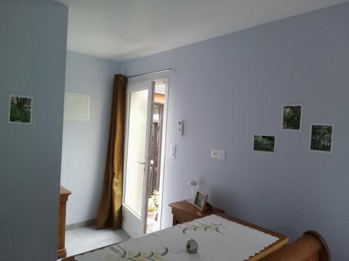 a white bedroom with a bed and a window at le studio de la salamandre in Cadillac