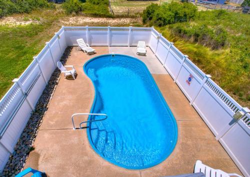 an overhead view of a swimming pool with two chairs at 4073 - Downtime in Kitty Hawk