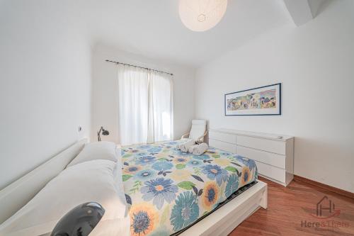 a bedroom with a bed with a floral bedspread at SeaSoul - Mare 100m - 6 Guests - Centro Storico in Albissola Marina
